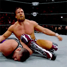 two men are wrestling in a ring with tnt written on the ring