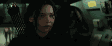 a woman is sitting in a car with a bow and arrow in her hand .