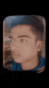 a close up of a young man 's face with a blue shirt