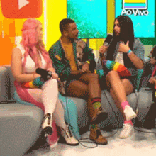 a group of people sitting on a couch with a ao vivo logo in the background