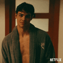a shirtless man is wearing a robe with the word high embroidered on it
