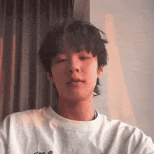 a young man wearing a white t-shirt that says ' i 'm a ' on it
