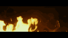 a person is laying on the ground in front of a large fire