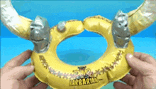a person is holding an inflatable ring with horns and the word barbarian on it