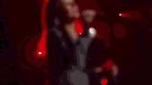 a woman singing into a microphone in front of a red background