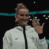 a woman wearing a white jacket that says femt beauty