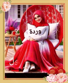 a woman in a red dress is sitting in a red chair holding a pillow with arabic writing