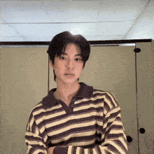 a young man in a purple and white striped shirt
