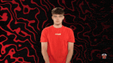 a man wearing a red shirt that says t-shirt is holding a card in front of his face