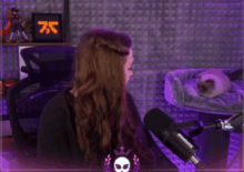 a woman sitting in front of a shure microphone in a room