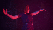 a woman is dancing in a dark room with red lights