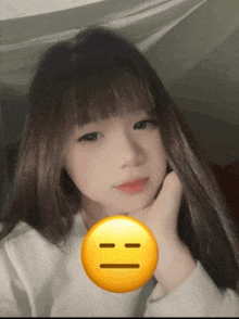 a girl with a yellow smiley face in front of her face