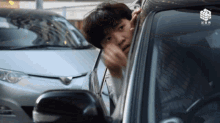 a man talking on a cell phone while looking out of a car
