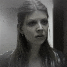 a black and white photo of a woman 's face with a serious look on her face
