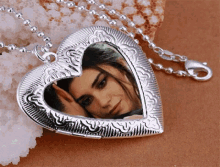 a silver heart shaped locket with a picture of a woman in it