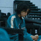 a person wearing a blue jacket with the number 067 on the front