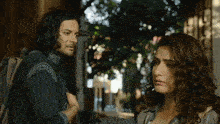 a man and a woman are looking at each other on a street
