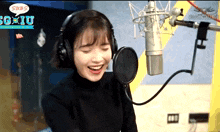 a woman wearing headphones is smiling in front of a microphone with a speech bubble that says subs on it