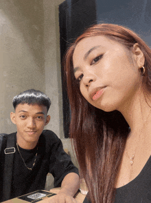 a man and a woman are sitting at a table with a qr code on their phone