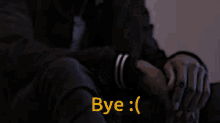 a man in a dark room with the word bye in yellow