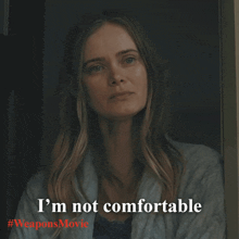 a woman says i 'm not comfortable in front of a weapons movie poster