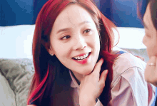 a woman with red hair is smiling and looking at the camera