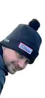 a man wearing a black beanie with a patch that says titleist on it