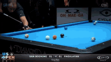 a pool table with a sign that says oh-mae-ga in the background