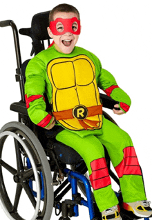a young boy in a wheelchair is dressed in a turtle costume