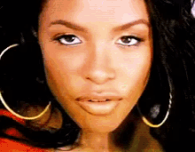 a woman wearing hoop earrings looks at the camera