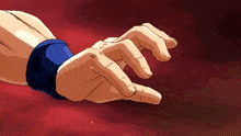 a close up of a person 's hand with a blue wristband on it