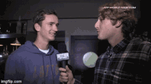 a man is holding a microphone that says nextbox on it