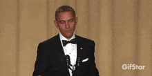 a man in a tuxedo is dancing in front of a gifstar logo ..
