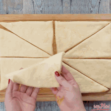 a person folding a piece of dough on a wooden cutting board with easy plans written on the bottom