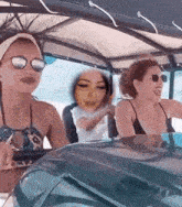 a woman in a bikini is driving a car with a picture of her face on the windshield .