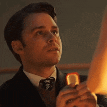 a man in a suit and tie is holding a ring in his hand