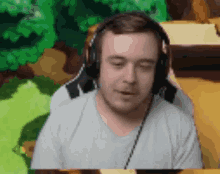 a man wearing headphones and a white shirt is looking down