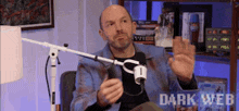 a man is sitting in front of a microphone with the words dark web written on the bottom