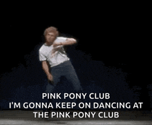 a man in a white shirt is dancing on a stage .