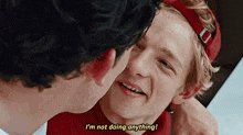 two young men are kissing each other and one of them is saying `` i 'm not doing anything ! ''
