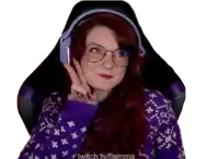 a woman wearing a purple sweater and headphones is sitting in a chair