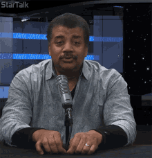 a man sitting in front of a microphone with startalk written on the bottom