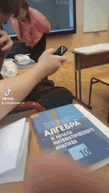 a person taking a picture of a book titled algebra