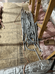 a bunch of metal pipes are laying on a wooden floor with a label that says ' aluminum ' on it