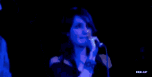 a man in a joe boxer shirt stands next to a woman singing into a microphone on stage