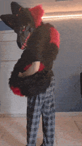 a person in plaid pants is holding a stuffed animal in their arms