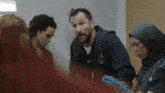 a group of people are sitting around a table in a hospital room .