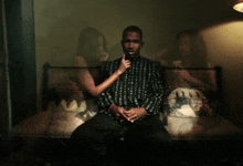 a man sits on a couch with a woman standing behind him