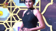 a woman stands in front of a bollywood royal sign