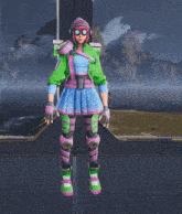 a woman in a green jacket and blue skirt is standing in front of a mountain range .